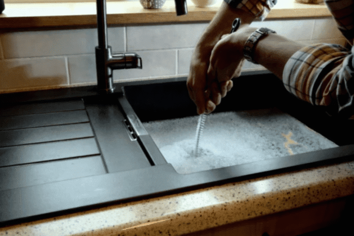 A sink overflowing from a clogged drain, showing signs of a severe blockage.