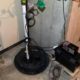 Licensed plumber installing a new submersible sump pump in an Elgin IL home basement
