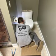 Licensed plumber performing toilet repair in Elgin IL bathroom