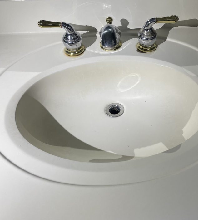 Common DIY bathroom plumbing mistakes in Elgin IL Elgin homeowner inspecting bathroom sink plumbing under vanity