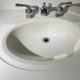 Elgin homeowner inspecting bathroom sink plumbing under vanity