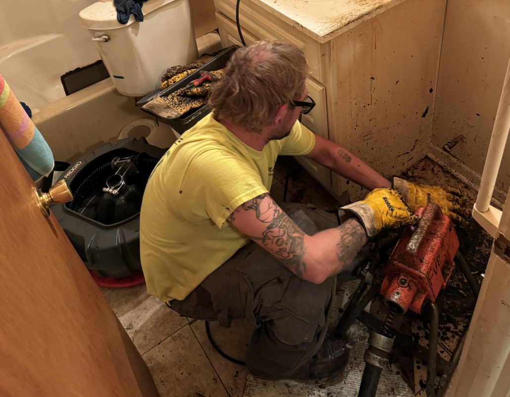 Plumber performing toilet drain cleaning service in Elgin IL