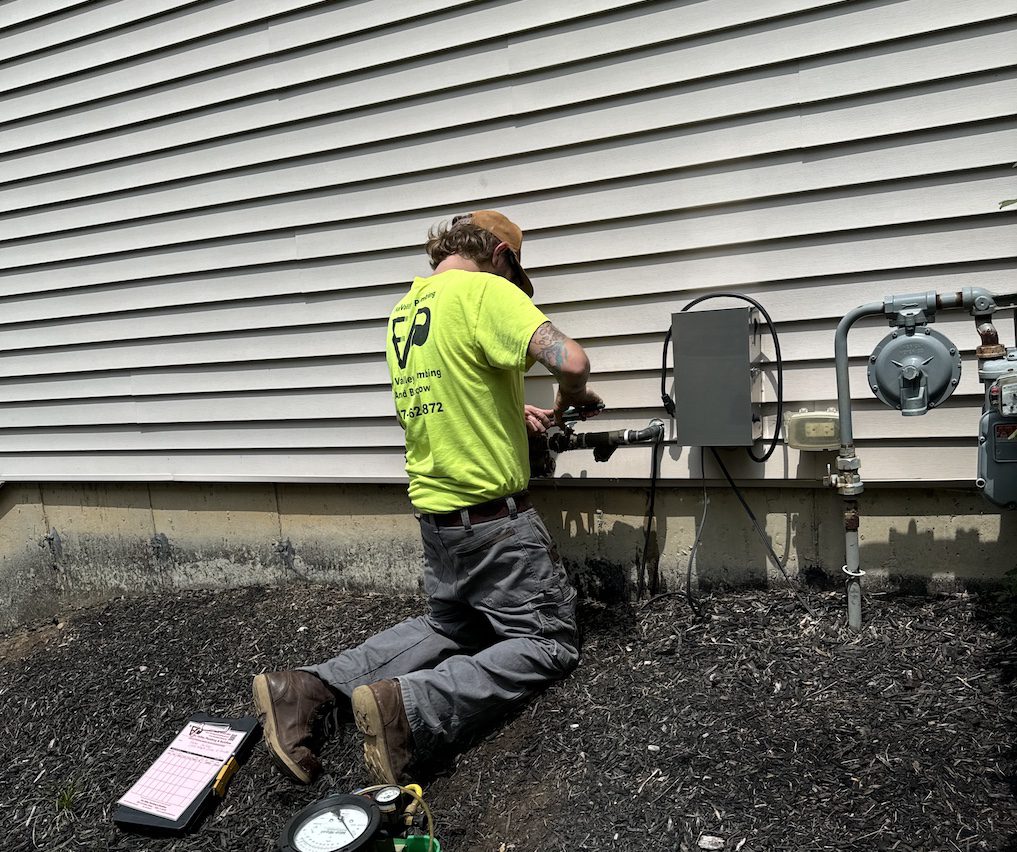 Licensed plumber performing residential plumbing installation in an Elgin IL home