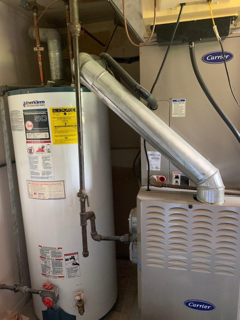 Licensed master plumber performing water heater repair in an Elgin IL home