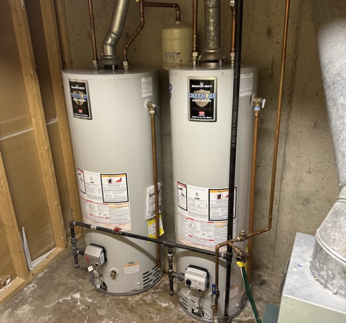 Plumber inspecting a water heater in an Elgin IL home before the holiday season